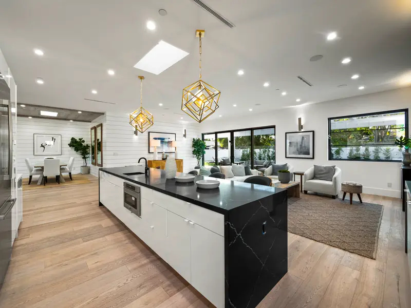 Kitchen countertops in Los Angeles, CA: black island countertop with white veining in a white kitchen