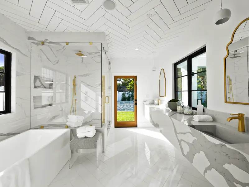 Vanity countertop in Los Angeles, CA: bathroom with veined white stone surfaces, vanity and glass shower
