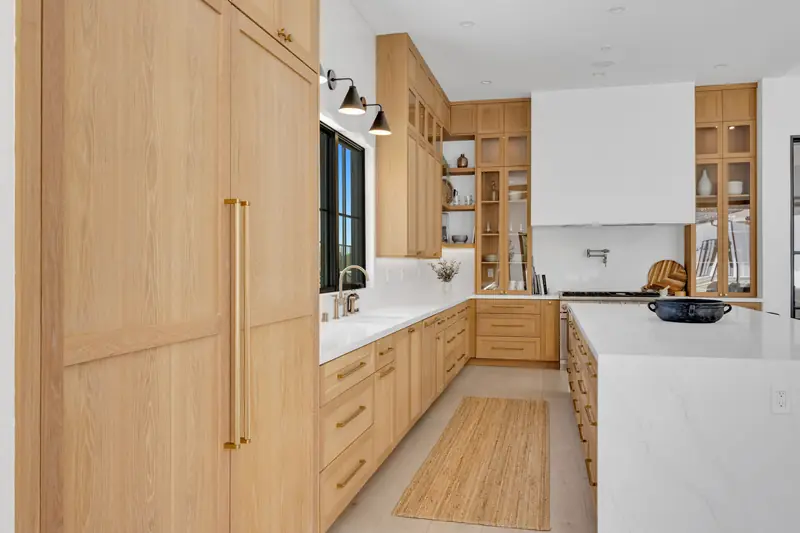 Kitchen countertops in Porter Ranch, CA: oak kitchen with white stone countertops and a full-height backsplash