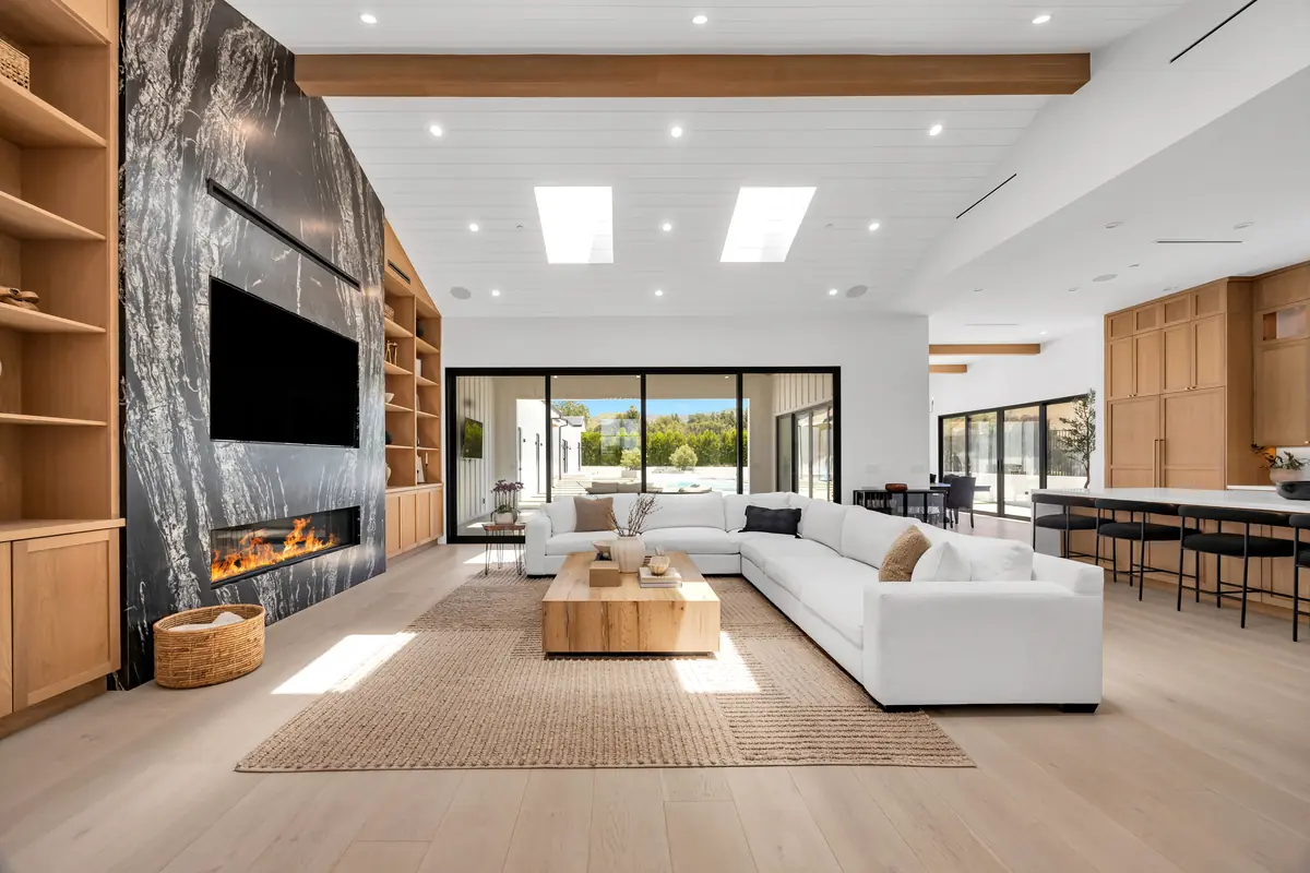 Slab fireplace in Porter Ranch, CA: living room with a full-height slab fireplace wall and oak shelving