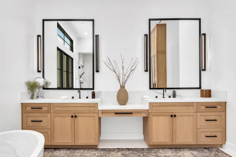 Vanity countertop in Porter Ranch, CA: oak double vanity with a white countertop and black-framed mirrors