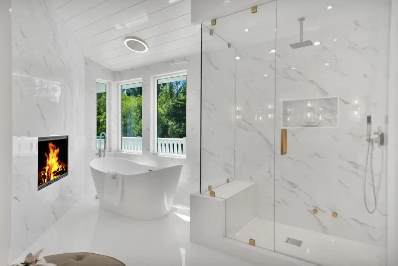 Slab fireplace in Sherman Oaks, CA: bathroom with a slab-clad fireplace wall, tub and glass shower